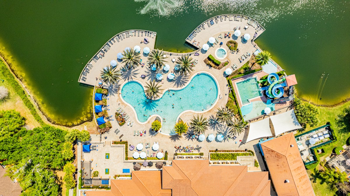 Top-down aerial of the resort pool with cabanas beside the lake in Kissimmee