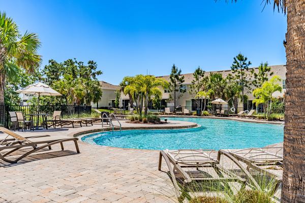 Community pool with loungers beside a lake in Palmetto