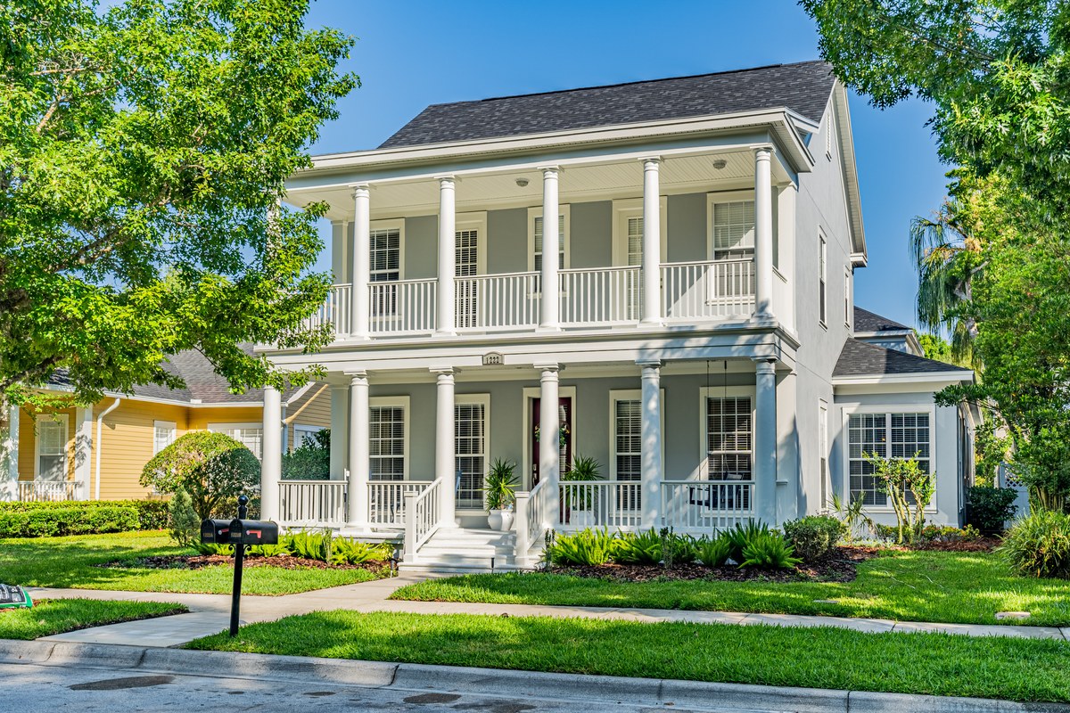 White two-story home with stacked double front porches and columns in Celebration