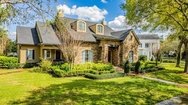 Elevated view of a stone and stucco home with a landscaped front lawn in Celebration