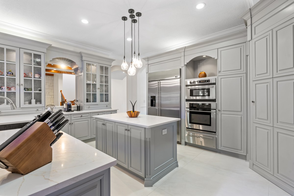Gray kitchen with an island, double ovens and pendant lights in Celebration