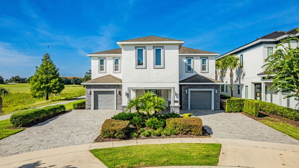 Elevated view of a white two-story home with two garage bays in Champions Gate