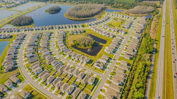 Aerial of a large townhome community beside a highway and retention ponds in Odessa