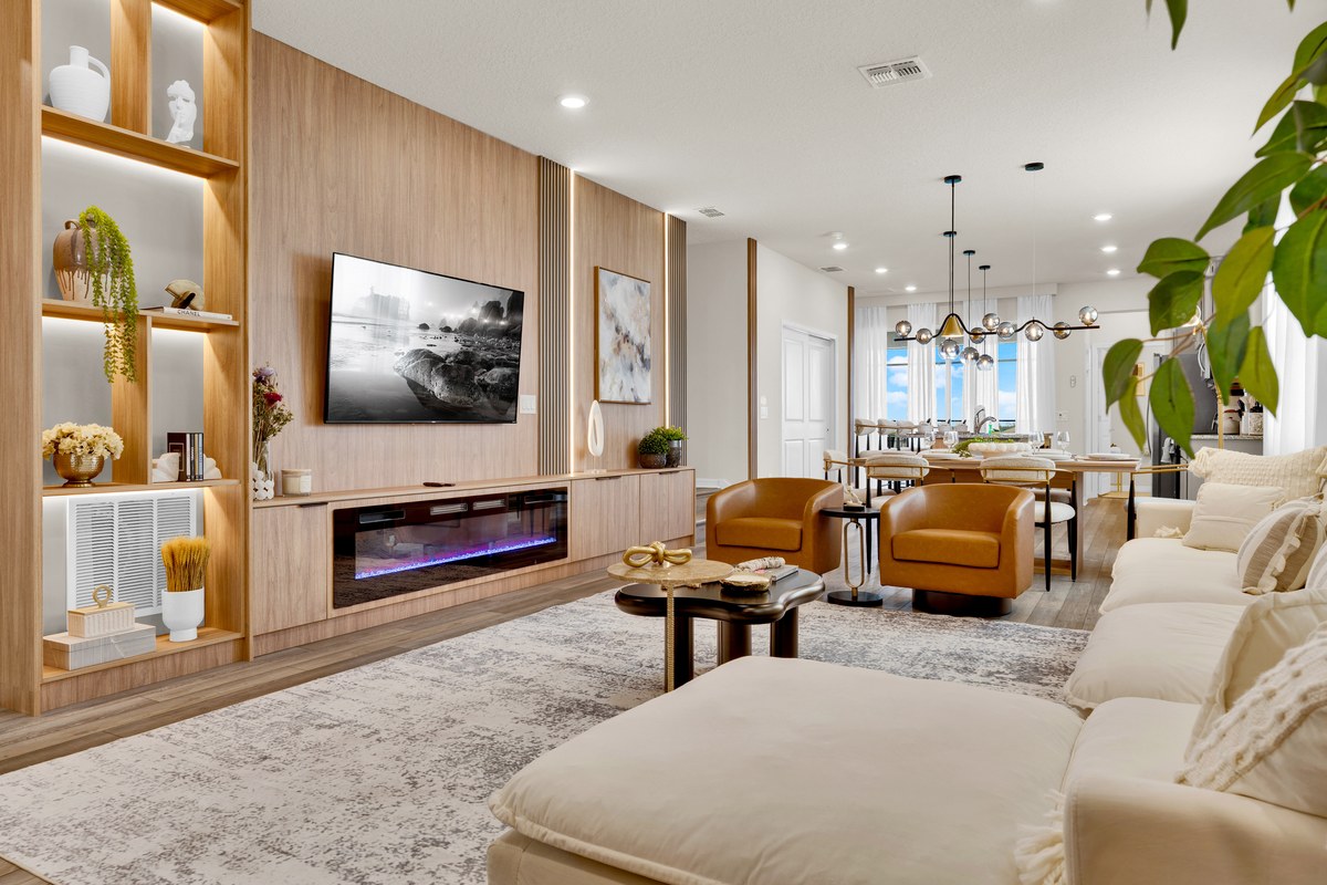 Living room with a linear fireplace, shelving and a wall-mounted television in Davenport