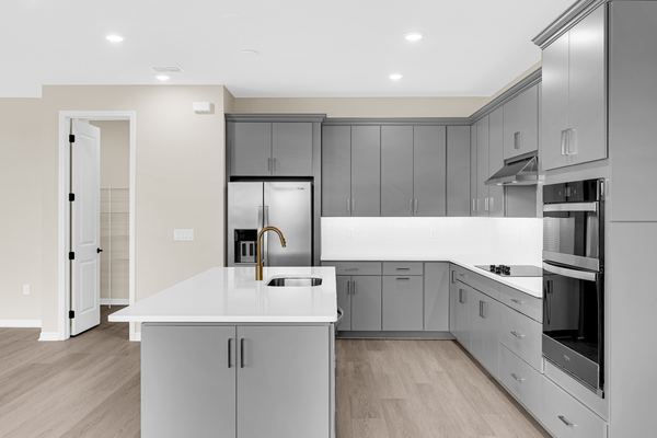 Gray kitchen with an island and wall ovens in Hamlin