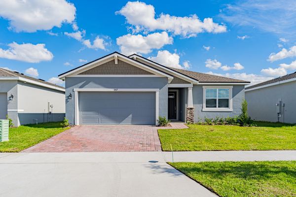 Gray single-story home with a brick paver driveway in Kissimmee