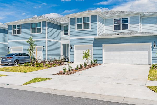 Blue two-story home with an attached garage and new landscaping in Kissimmee
