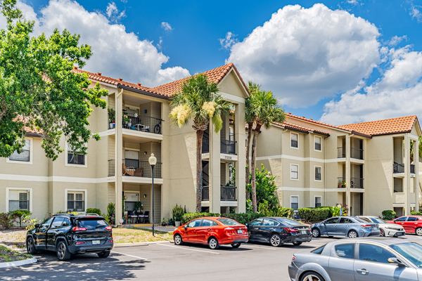 Three-story condominium building with a tile roof and resident parking in Kissimmee