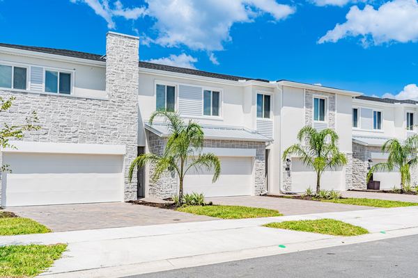 Townhome row with a stone facade and young palms in Kissimmee