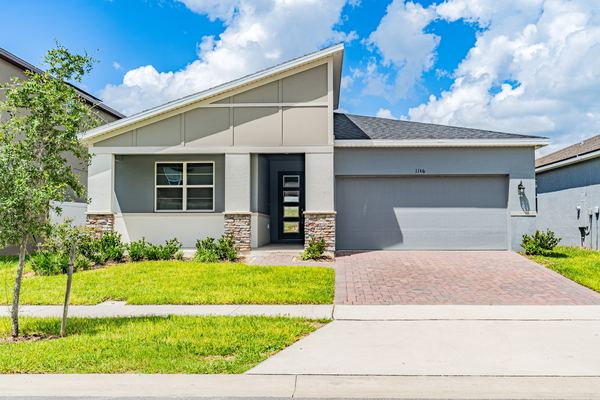 Gray single-story home with a modern glass entry door in Kissimmee