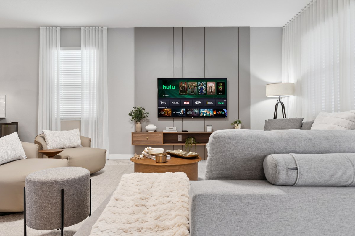 Living room with a cream sofa and a wall-mounted television in Kissimmee
