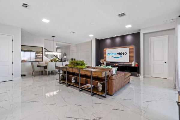 Living room with marble floors and a television showing a streaming service in Lake Nona