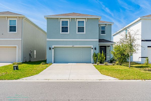Blue-gray two-story home with an attached garage in Odessa