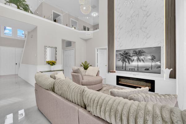 Two-story living room with a curved sofa and a fireplace in Orlando