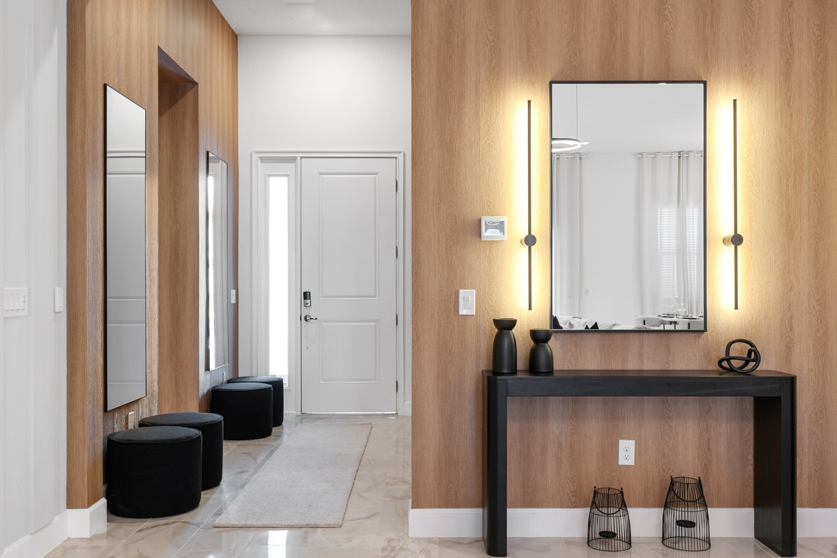 Entry hall with a console table, mirror and lit sconces in Orlando