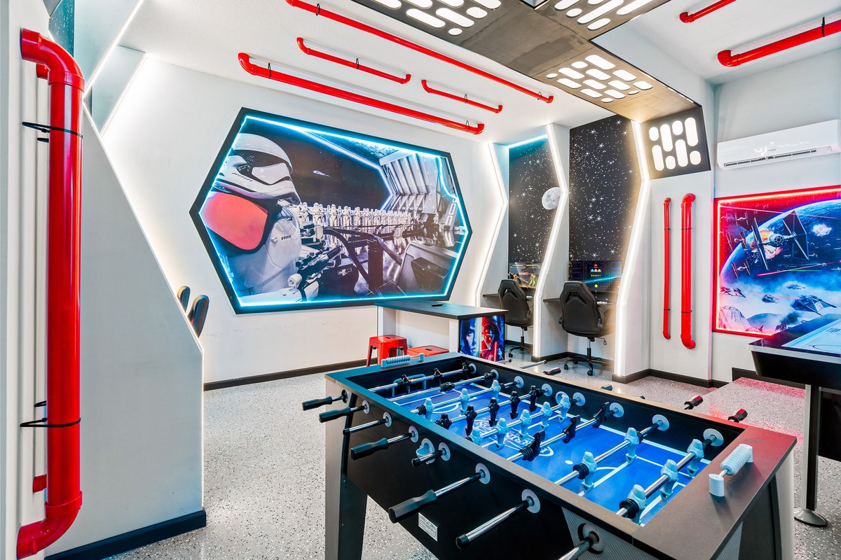 Space-themed game room with foosball and an arcade screen in Orlando