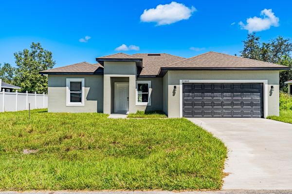 Gray single-story new-build home with a dark garage door in Port Charlotte