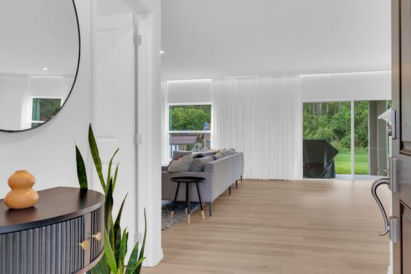 Entry with a fluted console, mirror and the living room beyond in St. Cloud