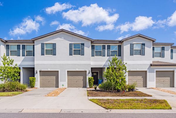 Gray townhome row with paired garages in Wesley Chapel
