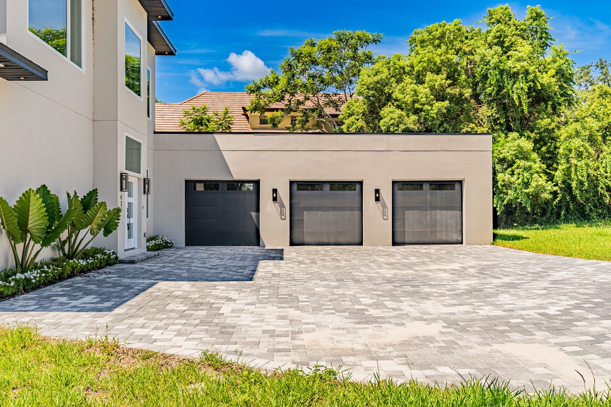 The modern white home and its garage wing from the opposite side in Windermere