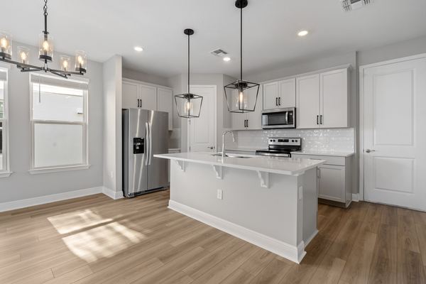 White kitchen with an island and pendant lights in Winter Garden