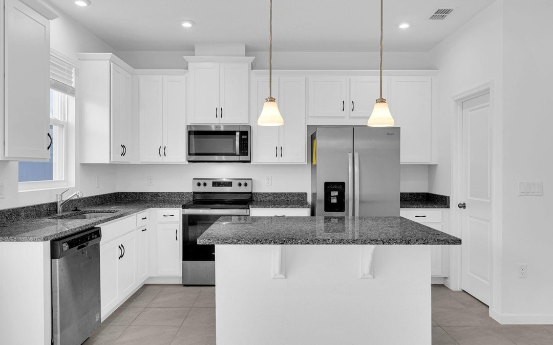 The same kitchen photographed by SunHaus: white cabinets, even light and level verticals.